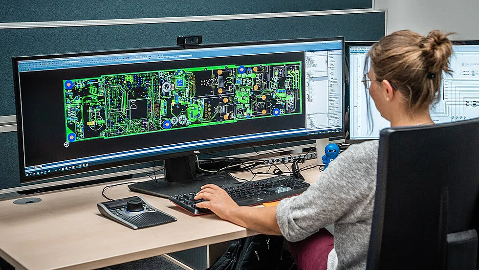 Student designing a PCB layout using software for electronics engineering project