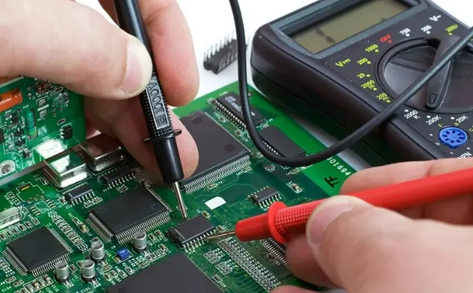Technician probing PCB test point with multimeter for troubleshooting