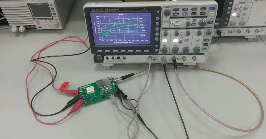Technician debugging hotel room control PCB using oscilloscope.