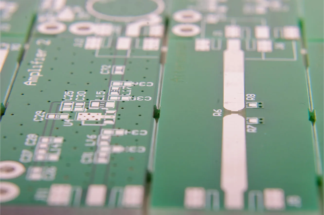 V-scoring machine cutting grooves on a PCB panel with FR-4 laminate.