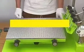 Manual silkscreen printing setup for PCB with stencil and white ink.