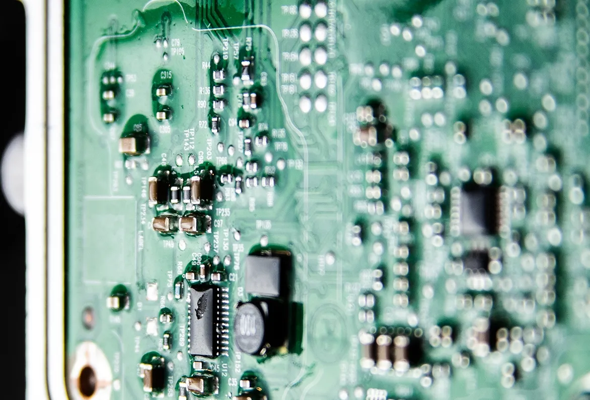 Close-up of a PCB with conformal coating for space probe protection.