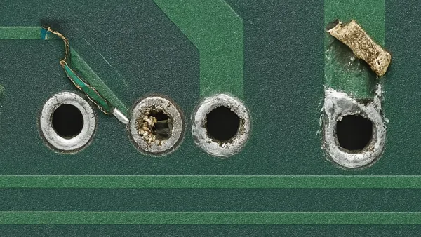A repaired plated through-hole on a PCB with a soldered eyelet