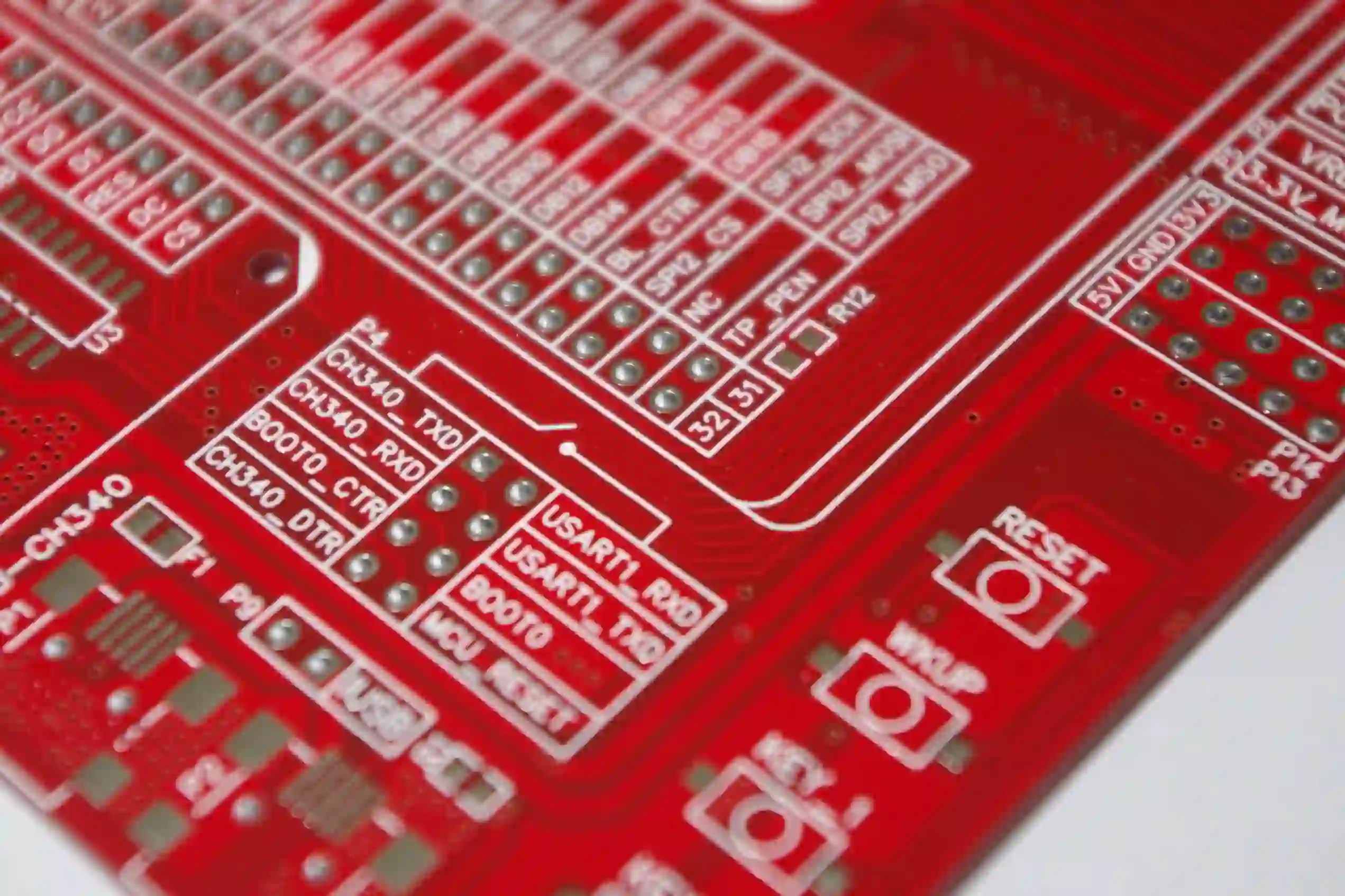Red-PCB-with-microcontroller-and-connection-pins-scaled
