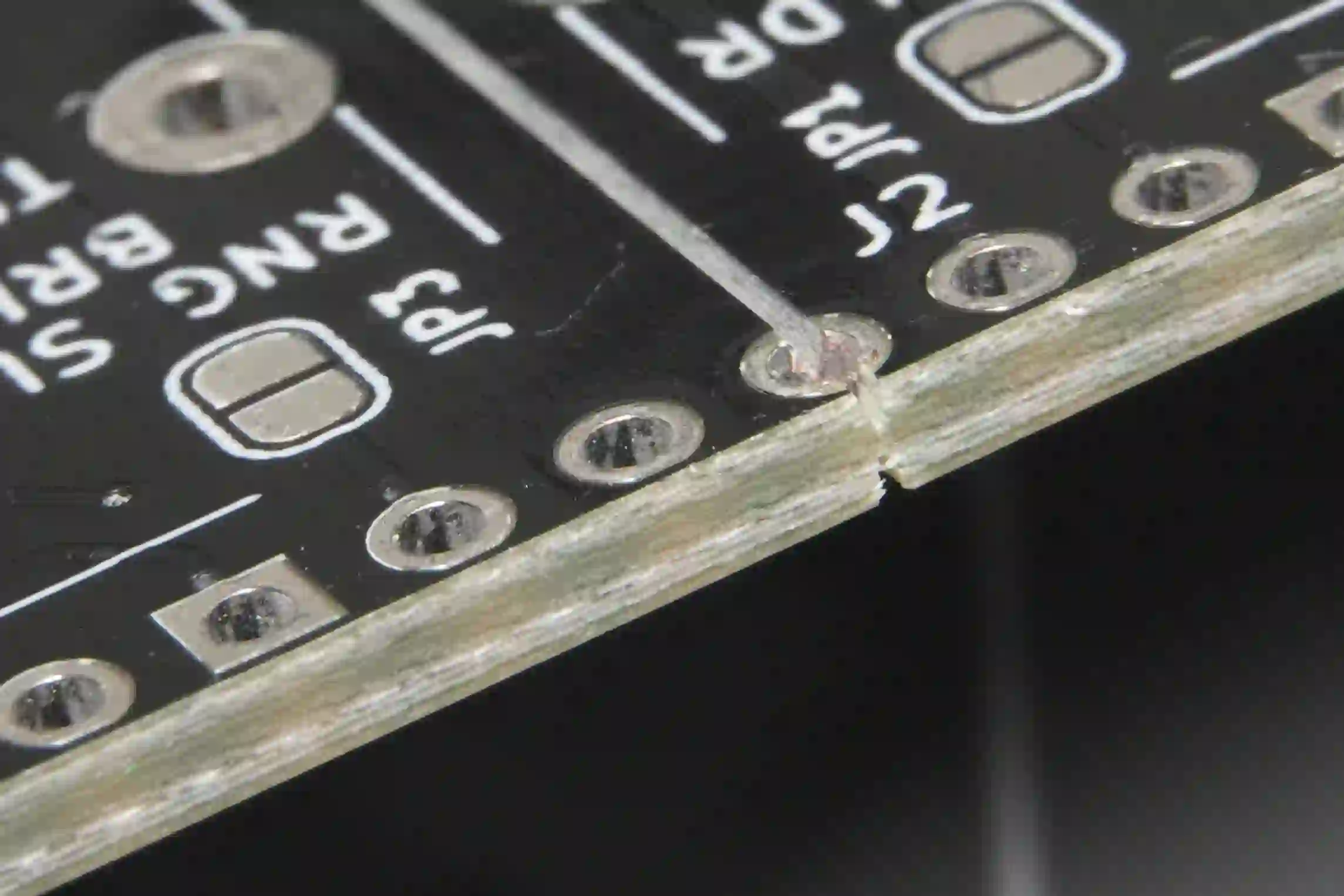 Close-up of V-groove scoring on a PCB panel illustrating depaneling break line