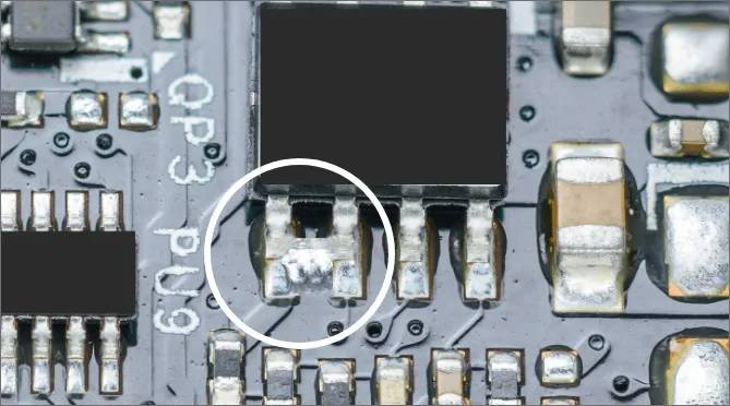 PCB showing solder bridging defect due to improper solder mask contact.
