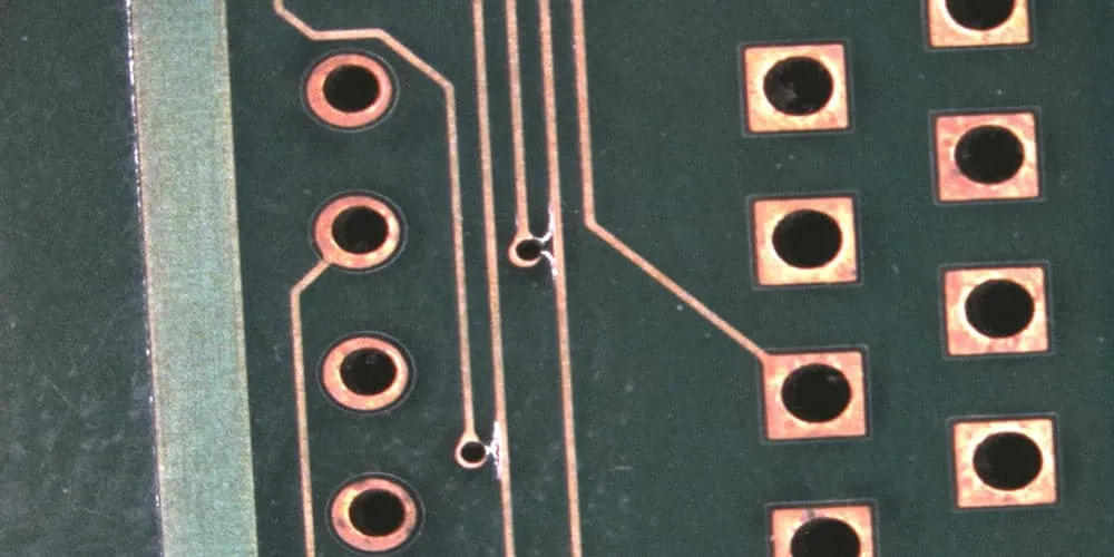 Close-up of a PCB showing intact and damaged plated through-holes