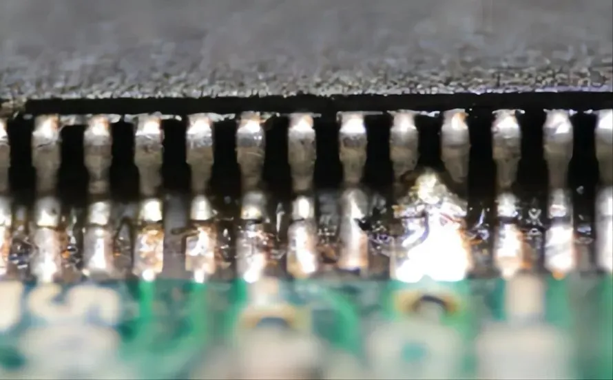 Close-up of a solder bridge on a PCB causing a short circuit