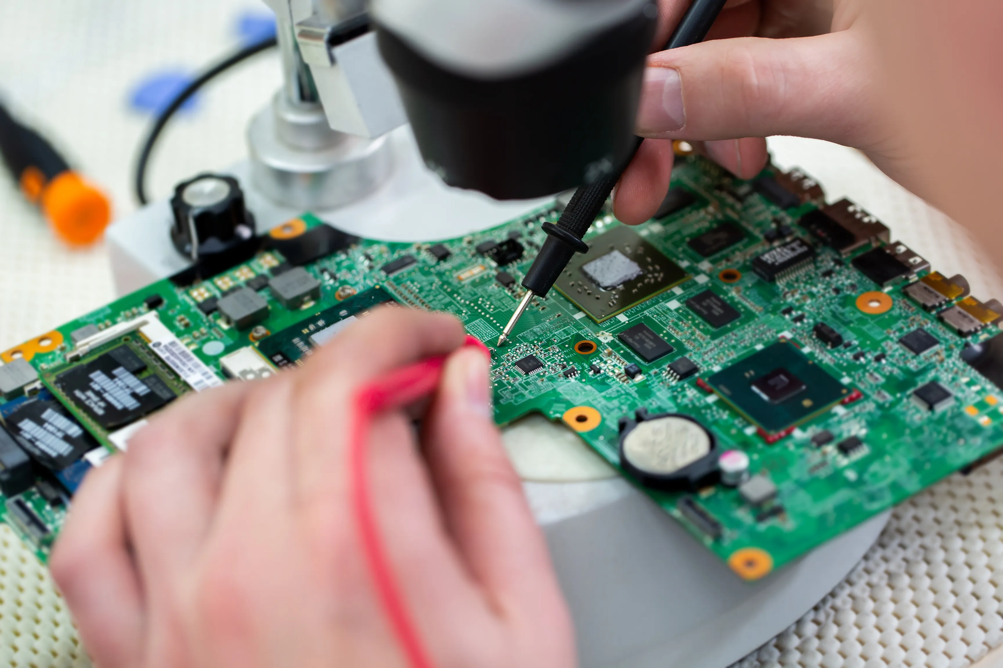 Technician performing PCB rework with adequate component spacing.