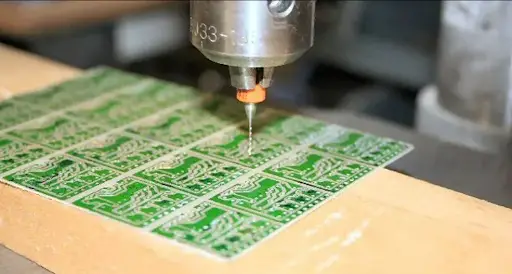 Mechanical drilling of a PCB with precision drill bit.