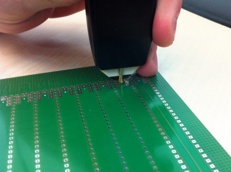 Technician measuring controlled impedance on a PCB test coupon'