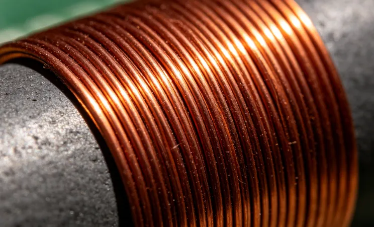 Close-up of even wire tension during diy inductor winding on a ferrite rod